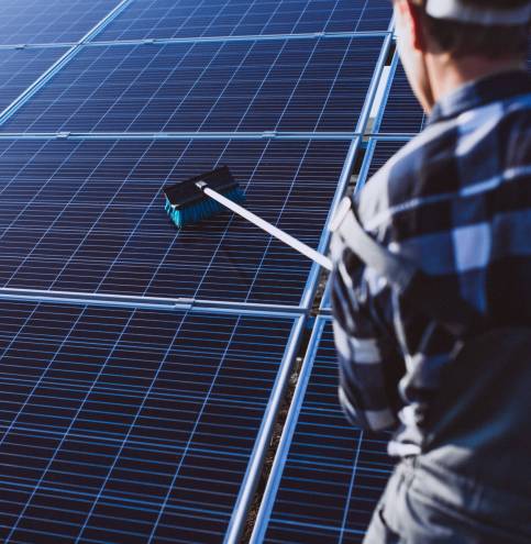 Man worker in the firld by the solar panels Man worker in the firld by the solar panels